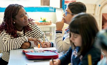 elementary teacher working with a small group of students in class