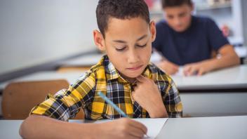 Elementary boy in yellow plaid shirt taking a test