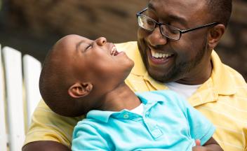 Young father talking and laughing with preschool son