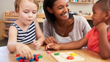 preschool teacher with two kids working on colors and shapes