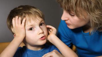 Adult sitting close to young child for a conversation