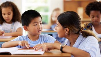 Elementary teacher working with student during reading instruction