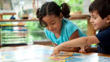 Two elementary kids looking at map in class