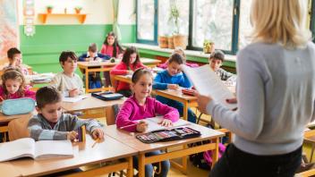 teacher reading text for students to practice writing