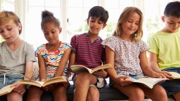 row of elementary kids reading books