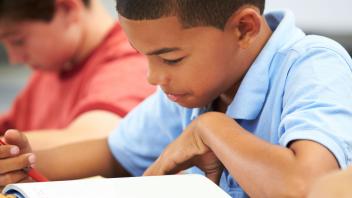 elementary student reading text closely in class