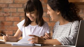 Mother and elementary age daughter working on homework together