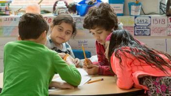 group of four elementary students practicing comprehension strategy together
