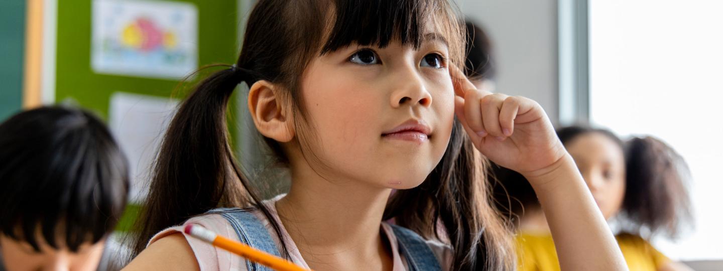 girl looks up with finger on temple, deep in thought