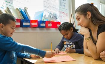 Elementary teacher working with two children at a small table